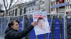 صورة لسيدة تحمل صورة رئيس بلدية إسطنبول أكرم إمام أوغلو.