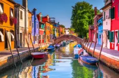 Canal de Burano, perto de Veneza, com ponte, barcos e casas coloridas
