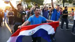 Un hombre con una bandera de Paraguay en una protesta de agricultores.