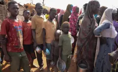 نازحون حديثاً يصطفون لتلقي وجبات الطعام في مخيم ثوبو، في مقاطعة إنجبونج، السودان