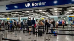 UK Borders for Terminal 5 wit arriving international travel passengers waiting for immigration control and passport check