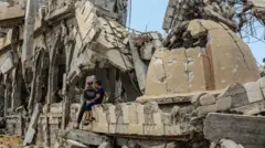 فلسطينيان عند حطام مسجد بلال بن رباح في خان يونس في قطاع غزة الذي تعرض لقصف إسرائيلي