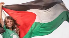 Greta Thunberg membentangkan bendera Palestina di sebuah kapal yang menjadi bagian dari Global Sumud Flotilla, yaitu iring-iringan sejumlah kapal bantuan ke Gaza.