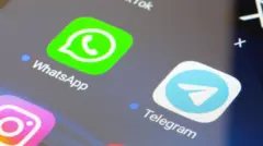 На экране телефона изображены два квадрата со скругленными углами. Один квадрат салатового цвета. В квадрате изображена телефонная трубка. Под квадратом надпись WhastApp. Другой квадрат белый. В нем голубой круг с изображением бумажного самолетика. Под квадратом надпись Telegram.