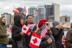 Uma manifestação "Unindo Nossa Amizade" às margens do Rio Detroit rejeita o que descreve como uma atitude anti-canadense do governo Trump. Uma manifestação semelhante ocorreu do outro lado do rio, em Windsor, Ontário, e em outras travessias de fronteira em Michigan e Ontário.