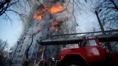 Rescuers work next to a residential building damaged by shelling, as Russia"s attack on Ukraine continues, in Kyiv, Ukraine, in this handout picture released March 15, 2022.