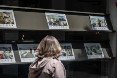 Una persona observa anunciós de viviendas dispobibles en el escaparate de una agencia inmobiliaria en Barcelona.