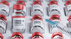 شیشه‌های واکسن کرونا و یک سرنگ