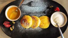 Travessa de café da manhã com pequenos pães e complementos