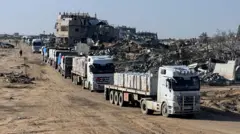 شاحنات تحمل مساعدات تتحرك، في رفح جنوب قطاع غزة، 13 فبراير/شباط 2025. 