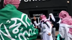 سعوديون يرفعون علم بلادهم