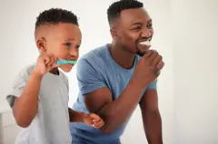 Père et fils qui se brossent les dents