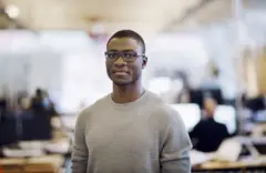 Un homme pose fièrement dans son lieu de travail