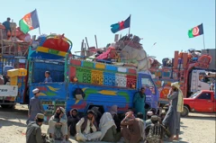 Юк машиналари ёнида ўтирган Афғонлар