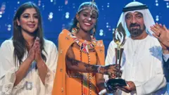 ቀበሌ ዱባ (መሃል) ሽልማት ስትቀበል።