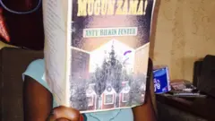 Wata mace tana karanta littafin Hausa