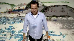 Vik Muniz diante de um de seus trabalhos