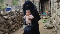 मोना आणि तिचा मुलगा जेरार्ह त्यांच्या राहात्या घरी 