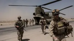 US troops walk off a helicopter on the runway at Camp Bost in 2017 in Helmand Province
