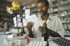 Un homme dans une officine de pharmacie.