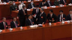 هو جین‌تائو، رهبر سابق چین، توسط مقامات کنگره حزب کمونیست به بیرون هدایت می‌شود، اکتبر ۲۰۲۲