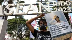 Seorang aktivis membawa poster saat aksi menuntut penanganan pencemaran udara di Balaikota DKI Jakarta, Jakarta, Rabu (16/8/2023).