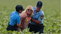 Sofia Gatica being led away from a frield