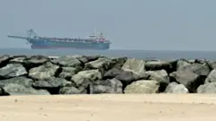  Navio no Golfo Pérsico, visto do litoral de Sharjah, um dia depois do fracasso das conversações de paz entre os EUA e o Irã no dia 13 de abril de 2026
