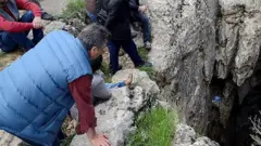 تجمع أرمني حول حفرة عميقة يعتقد أنها كانت مقبرة جماعية للأرمن في جبل قرب مدينة ديار بكر . 22 أبريل/نيسان 2015.