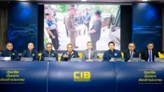 Agentes de policía sentados detrás de una mesa larga.