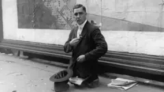 Um homem sem pernas vende lápis nas ruas em 1910