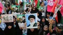 Manifestantes anti-Israel e anti-EUA portando fotos do aiatolá Ali Khamenei em Teerã (Irã), no dia 14 de junho de 2025