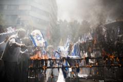 Hombres queman banderas de Israel en una manifestación en Teherán.