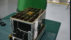 صورة من وكالة الفضاء السعودية SSA للقمر الصناعي المكعب شمس وبجواره علم المملكة الأخضر