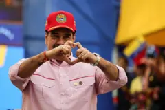 Presidente da Venezuela, Nicolás Maduro, fazendo sinal de coração com as mãos. Ele usa um boné vermelho
