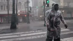 Человек переходит улицу во время урагана "Ида"