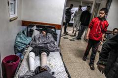 An injured youth lies on a bed at a makeshift camp in an area of the European Hospital in Khan Yunis in the southern Gaza Strip on December 31, 2023