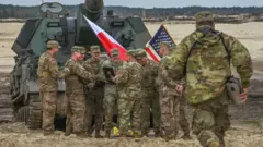Amerikai katonák láthatók egy kiképzési gyakorlat végén, amelyben ABRAMS harckocsikat is alkalmaztak nowa dęba-i gyakorlótéren, 2023. április 12-én, a lengyelországi Nowa Dębában. 