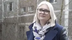 柳德米拉·洪查站在烏克蘭普裏皮亞特舊居前