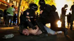 Сербские жандармы прижимают к земле мужчину с голым торсом