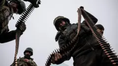 військові тримають кулеметну стрічку