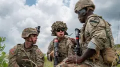 trojica američkih vojnika u vojnoj opremi 