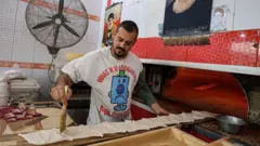 बेकरीत काम करताना एक कर्मचारी 