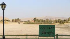 تابلوی «شنا ممنوع» جلوی دریاچه سرآب نیلوفر که خشک شده است. 