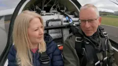 在飛機駕駛艙內的記者凱瑟琳·達·科斯塔 (Katharine Da Costa) 和比爾·布魯克斯 (Bill Brooks)