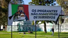 Outdoor rasgado com a foto de Ventura e a frase "Os imigrantes não podem viver de subsídios".