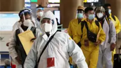 29일 인천국제공항 제1여객터미널에 방호복과 페이스 쉴드를 착용한 해외 입국자들이 이동하고 있다.