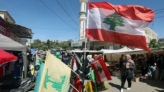 أشخاص يسيرون في شارع في لبنان وعلم لبناني.