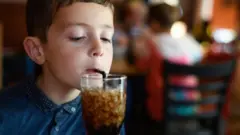 Un niño tomando soda