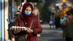 İranlı bir kadın, elinde yumurta kutusuyla Tahran'daki bir sokak pazarında y&uuml;r&uuml;yor.